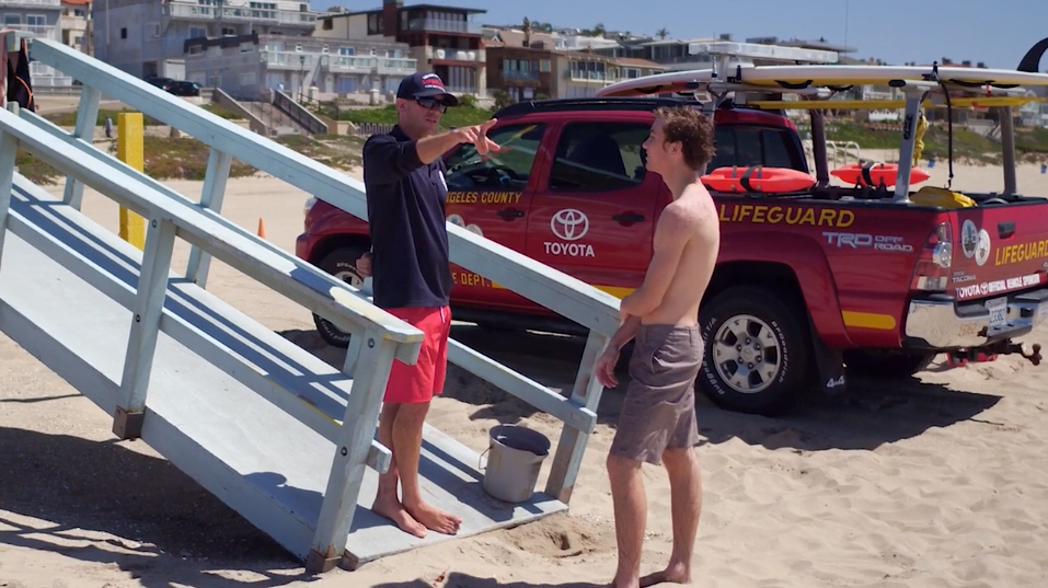 Lifeguard talking to person.