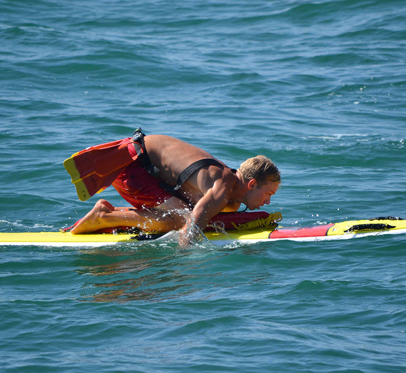 Lifeguard on a surf board training.