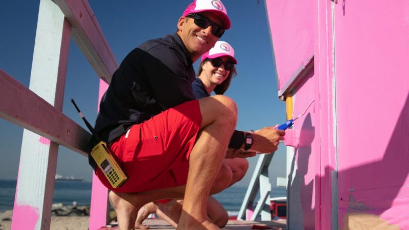Two lifeguard staff painting tower pink