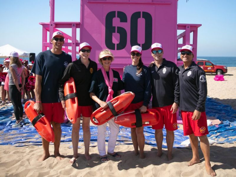 six people standing in front of pink lifeguard tower 6